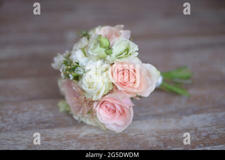 Brautstrauß mit selektivem Fokus auf pinkfarbenen und weißen Rosen und verschwommenem, weichem Holzhintergrund, elegantes Blumenarrangements für die zukünftige Braut Stockfoto