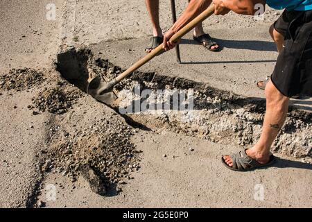 Der Prozess der Verlegung der Bürgersteig-Bordsteinkante. Die Arbeiter bereiten einen Graben für die Platzierung eines Betonklotz vor. Stockfoto