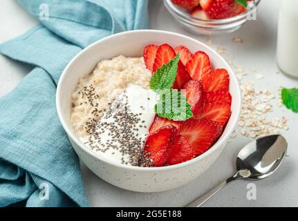 Ein Teller Haferflocken mit Erdbeeren, Joghurt und Chiasamen. Gesundes Frühstück. Stockfoto