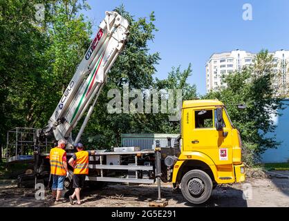 Ein Auto mit einer hydraulischen Aufzugsanlage im Innenhof eines Wohngebäudes.die Arbeit der Stadtwerke, Moskau, Russland Stockfoto