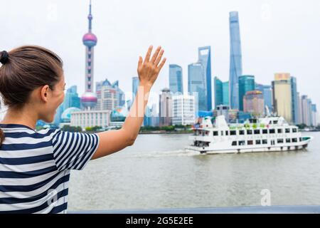 Frau winkt Auf Wiedersehen bei der Kreuzfahrt, die Shanghai verlässt Stockfoto