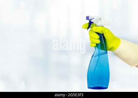 Frühjahrsputz-Konzept. Sprühflasche Mit Handgriff. Frau, die eine Flasche Waschmittel auf weißem Hintergrund hält. Allgemeine oder regelmäßige Reinigungsarbeiten Stockfoto