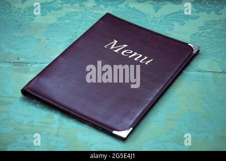 Bukarest, Rumänien - 22. Juni 2021: Die Speisekarte eines Restaurants sitzt auf einer schmutzigen Tischdecke. Stockfoto