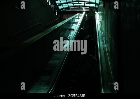 Bukarest, Rumänien - 22. Juni 2021: Die Reflexion des Lichts, das durch die verglaste Decke geht, leuchtet in starkem Kontrast auf der Rolltreppe am e Stockfoto