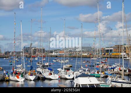 Flottille von Segelschiffen auf dem Fluss Liffey während des Tall Ships Festivals, Dublin, Irland 2012. Die Gebäude am Kai und die Mautbrücke sind geöffnet. Stockfoto