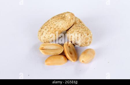 Erdnüsse isoliert auf weißem Hintergrund. Es gibt separate Erdnusskerne. Nahaufnahme Stockfoto