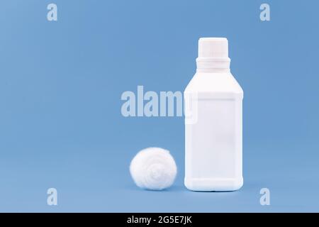 Plastikbehälter, Flasche antiseptisches Wasserstoffperoxid mit Baumwolle, Medizin mit blauem Hintergrund ohne Etikett Stockfoto