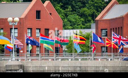 WESTPORT, CT, USA - 26. JUNI 2021: An schönen bewölkten Tagen winken Flaggen auf der Brücke über den Saugatuck-Fluss Stockfoto