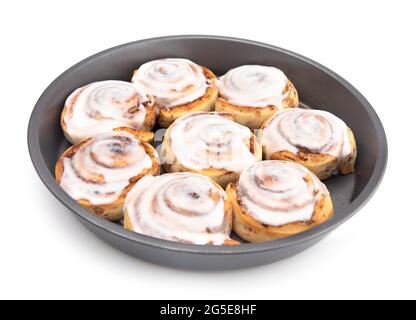 Frische Zimtbrötchen mit weißer Vereisung in einer Backform Stockfoto