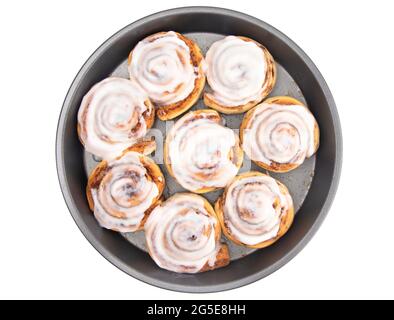 Frische Zimtbrötchen mit weißer Vereisung in einer Backform Stockfoto