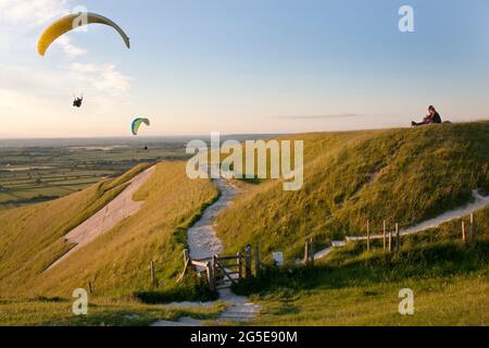 Gleitschirmflieger im White Horse Iron Age Hill Fort, Bratton, Westbury, Wiltshire, England Stockfoto