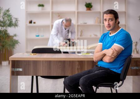 Alter Tierarzt untersucht Hund in der Klinik Stockfoto