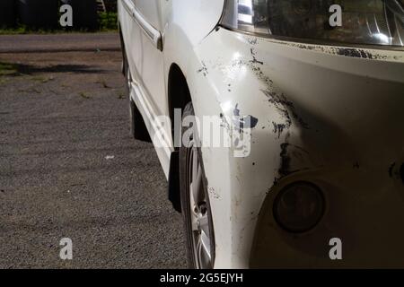 Am vorderen Stoßfänger beschädigt. Kratzer auf weißem Auto nach Unfall. Am Morgen Stockfoto