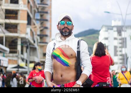 Ein Mitglied der LGTBQ-Gemeinschaft hat am 25. Juni 2021 in Pasto, Narino - Kolumbien, eine stolze Fahne auf seiner Brust bei der jährlichen Parade zur Forderung nach LGTBQ-Rechten in Kolumbien. Stockfoto