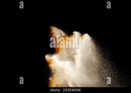Braune Farbe Sand Spritzer vor schwarzem Hintergrund. Stockfoto