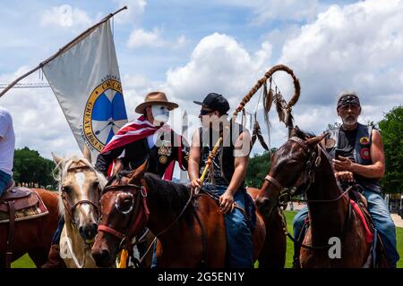 Washington, DC, USA, 26. Juni 2021. Im Bild: Drei Mitglieder einer Gruppe aus Nebraska, die Pferde in die National Mall gebracht hat, um auf das aufmerksam zu machen, was sie als die ungerechte Behandlung von Leonard Peltier bei einer Veranstaltung zum Abschluss des Freedom Ride for Voting Rights ansehen. Die Fahrt besuchte mehrere Städte im Süden, um die Wahrung der Stimmrechte zu fördern, da die Republikaner auf Bundesstaatsebene sich bewegt haben, um die Stimmabgabe zu erschweren. Kredit: Allison Bailey / Alamy Live Nachrichten Stockfoto