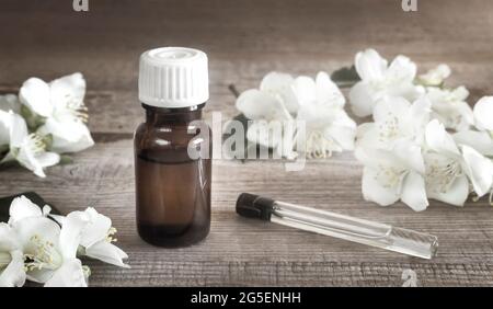 Jasminöl und weiße Jasminblüten auf dem Tisch Stockfoto