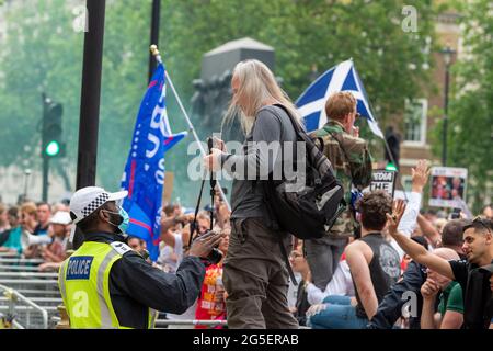 London, Großbritannien. Juni 2021. Nachdem ein Protestler bei zahlreichen Gelegenheiten von der Polizei gesagt wurde, von den Barrieren außerhalb der Downing Street abzusteigen, stand er während des ‘Unite for Freedom' in London weiterhin mit seiner Kamera auf ihnen. Kredit: SOPA Images Limited/Alamy Live Nachrichten Stockfoto