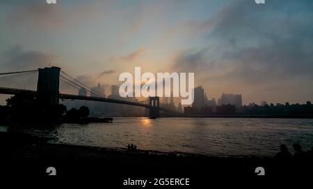 Blick auf die Lower East Side von Manhattan vom Brooklyn Bridge Park mit einem Nebel, der über die Manhattan Bridge hereinkommt. Stockfoto