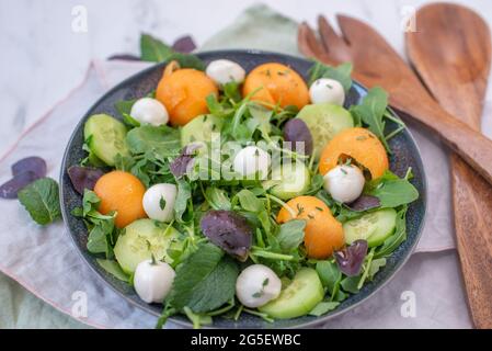 Frischer Sommersalat mit Rucola, Mozzarella und Melone Stockfoto