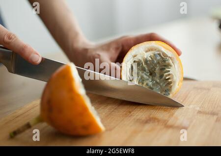 Frische, reife Bio-Granadilla oder gelbe Passionsfrucht, halbiert auf einem Holzbrett. Exotische Früchte, gesunde Ernährung Konzept Stockfoto