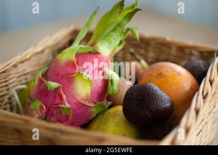 Großer Korb mit frischen tropischen Früchten, Passionsfrucht, Karambola, Drachenfrucht oder Pitaya, Mangostan, Lischi, Granadilla. Exotische Früchte, gesunde Ernährung Stockfoto