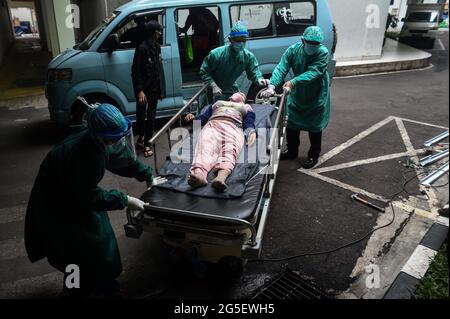 Jakarta, Indonesien. Juni 2021. Am 24. Juni 2021 verlegt das Gesundheitspersonal einen Patienten mit hohem Fieber nach Jakarta, Indonesien. Das Gesundheitsministerium sagte am 26. Juni 2021, dass das Land in den letzten 24 Stunden 21,095 neue COVID-19-Fälle verzeichnet habe, die höchste tägliche Spitze seit März letzten Jahres, als der erste COVID-19-Fall in dem Land entdeckt wurde, was die nationale Gesamtzahl auf 2,093,962 brachte. Quelle: Agung Kuncahya B./Xinhua/Alamy Live News Stockfoto