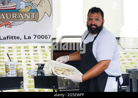 New Orleans, USA. Juni 2021. Ein Koch hält frisch gegrillte Austern während eines Meeresfrüchte-Festivals in Jean Lafitte, Louisiana, USA, am 26. Juni 2021. Das Seafood Festival findet hier vom 25. Bis 27. Juni statt. Quelle: Lan Wei/Xinhua/Alamy Live News Stockfoto