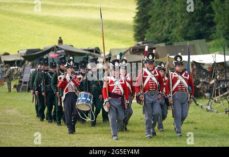 Mitglieder der Gruppe der lebenden Gewehre des 4. Königs und des 95. Königs marschieren zurück in ihr Lager, nachdem sie während des Chalke Valley History Festivals in Broad Chalke, in der Nähe von Salisbury, Wiltshire, der Öffentlichkeit eine Ausstellung gezeigt haben. Bilddatum: Samstag, 26. Juni 2021. Stockfoto