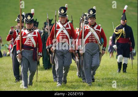 Mitglieder der eigenen lebenden Geschichtsgruppe des 4. Königs marschieren zurück in ihr Lager, nachdem sie während des Chalke Valley History Festivals in Broad Chalke, in der Nähe von Salisbury, Wiltshire, der Öffentlichkeit eine Ausstellung gezeigt haben. Bilddatum: Samstag, 26. Juni 2021. Stockfoto