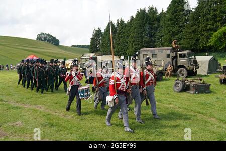 Mitglieder der Gruppe der lebenden Gewehre des 4. Königs und des 95. Königs marschieren zurück in ihr Lager, nachdem sie während des Chalke Valley History Festivals in Broad Chalke, in der Nähe von Salisbury, Wiltshire, der Öffentlichkeit gezeigt wurden. Bilddatum: Samstag, 26. Juni 2021. Stockfoto