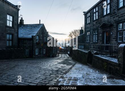 Blick auf Town Gate und Heptonstall Road in Heptonstall, Calderdale, Yorkshire, England an einem kalten, verschneiten Wintertag Stockfoto