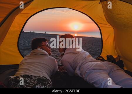 Paar schlafen im Zelt Blick auf Sonnenaufgang. Wanderkonzept. Strand Stockfoto