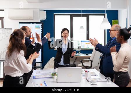 Fröhliche, vielfältige Mitarbeiter applaudieren nach erfolgreicher Präsentation. Multiethnical Partner Coworker feiern erfolgreiche Teamarbeit Ergebnis bei der Unternehmens-Briefing Stockfoto