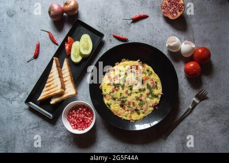 Gesundes Frühstück Speisen frittata serviert mit Brot zusammen mit Gewürzen. Draufsicht, selektiver Fokus. Stockfoto