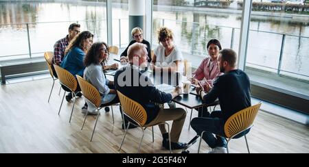 Geschäftsleute arbeiten und diskutieren gemeinsam in Besprechungen im Büro. Geschäftsmann diskutiert mit Kollegen, die am Tisch sitzen. Stockfoto