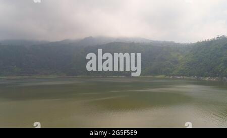 Luftaufnahme See Menjer in Nebel und Wolken. See in den Bergen mit grünen Regenwald. Tropische Landschaft mit Wald und See. Java Indonesien Stockfoto