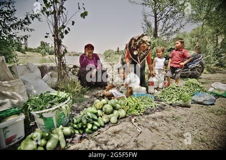 Ländlicher Agrarmarkt in der Türkei Gemüse- und Obststand, wo Kinder und muslimische Frauen mit traditionellem Kopftuch ihre Produkte verkaufen Stockfoto