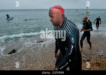 West Bay, Dorset, Großbritannien. Juni 2021. Der Wind sorgte dafür, dass die Schwimmstrecke des West Bay Triathlon auf 400 Meter verkürzt wurde, da die Teilnehmer am West Bay Triathlon an der Dorsets Jurassic Coast teilnehmen. Kredit: Tom Corban/Alamy Live Nachrichten Stockfoto