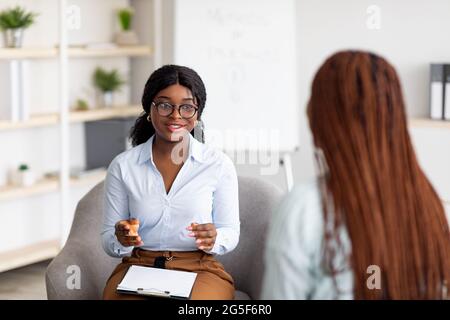 Psychotherapieberatung. Berater im Gespräch mit einer schwarzen Frau auf der Sitzung im Büro, Beratung für junge Klientin. Freundliche afroamerikanische Psychologen Stockfoto