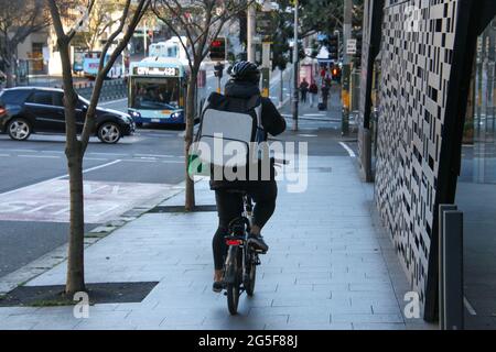 Sydney, Australien. Juni 2021. Nach einem Ausbruch des Covid-19 (Coronavirus) gelten die Bestellungen für den Aufenthalt zu Hause für den Großraum Sydney. Die zweiwöchige Sperrung mit „Stay-at-Home“-Bestellungen dauert bis Mitternacht, Freitag, den 9. Juli. Im Bild: Ein Lieferfahrer fährt illegal auf dem Fußweg entlang des Broadway. Kredit: Richard Milnes/Alamy Live Nachrichten Stockfoto