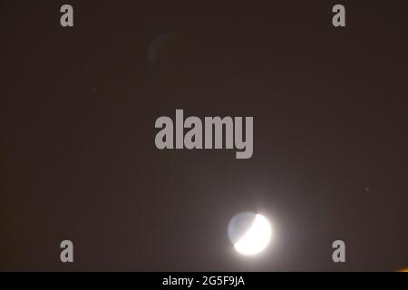 Mond im ersten Viertel in dunkelschwarzer Nacht Stockfoto