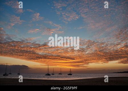 Tropisches Paradies mit Segelbooten Silhouetten im Hintergrund während des Sonnenuntergangs im Sommer Stockfoto
