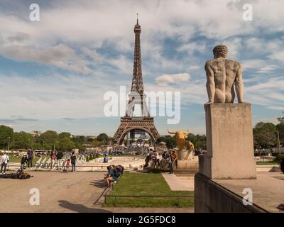 Paris, FRANKREICH - 2021. Mai: Der Eiffelturm, das Symbol von Paris, Vorderansicht, Touristen entspannen sich vor dem Hintergrund eines nicht funktionierenden Springbrunnens Stockfoto