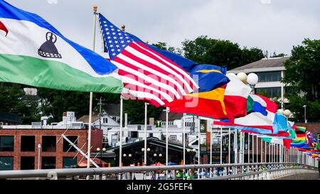 WESTPORT, CT, USA - 26. JUNI 2021: An schönen bewölkten Tagen winken Flaggen auf der Brücke über den Saugatuck-Fluss Stockfoto