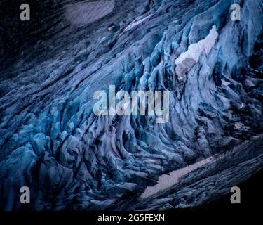 Auf dem alten, blauen Gletschereis auf dem Stein-Gletscher in Gadmen in der Schweiz sind weiße Schneeflecken zu sehen. Die Gletscher in den Alpen schmelzen aufgrund der globalen Erwärmung schnell, und viele von ihnen werden voraussichtlich bis 2070 verschwunden sein. Die weiße Schneedecke reflektiert das Sonnenlicht und die Hitze viel besser als das dunklere Eis. Im Winter 2017/2018 gab es in den alpen Rekordschneemengen, aber die Rekordtemperaturen im Sommer schmolzen den größten Teil bereits im Juni. Stockfoto