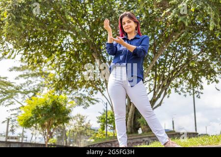 Stilvolle junge Frau im Freien gestikulieren mit ihren Händen Stockfoto