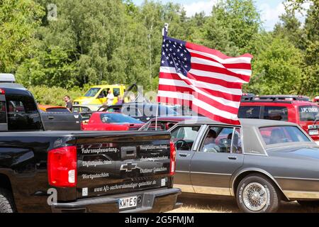 Königs Wusterhausen, Deutschland. Juni 2021. Die Flagge der Vereinigten Staaten fliegt auf einem Auto bei der Oldtimer-Parade 'Rummblubbern' in und um Königs Wusterhausen. Für die zweistündige Autokolonne werden mehr als 400 amerikanische Fahrzeuge erwartet. Die Strecke der Autokolonne wird etwa 40 km lang sein. Die Organisatoren erwarten Tausende von Gästen entlang der Strecke und in den Restaurants. Foto: Gerald Matzka/dpa Quelle: dpa picture Alliance/Alamy Live News Stockfoto