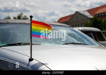 Königs Wusterhausen, Deutschland. Juni 2021. Bei der Oldtimer-Parade 'Rummblubbern' in und um Königs Wusterhausen fliegt eine Regenbogenfahne auf einem Auto. Für die zweistündige Autokolonne werden mehr als 400 amerikanische Fahrzeuge erwartet. Die Strecke der Autokolonne wird etwa 40 km lang sein. Die Organisatoren erwarten Tausende von Gästen entlang der Strecke und in den Restaurants. Foto: Gerald Matzka/dpa Quelle: dpa picture Alliance/Alamy Live News Stockfoto