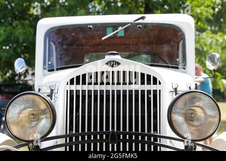 Königs Wusterhausen, Deutschland. Juni 2021. Bei der Oldtimer-Parade „Rummblubbern“ in und um Königs Wusterhausen steht ein 1933 gebauter Opel. Mehr als 400 amerikanische Fahrzeuge werden voraussichtlich an der zweistündigen Autokolonne teilnehmen. Die Strecke der Autokolonne wird etwa 40 km lang sein. Die Organisatoren erwarten Tausende von Gästen entlang der Strecke und in den Restaurants. Foto: Gerald Matzka/dpa Quelle: dpa picture Alliance/Alamy Live News Stockfoto